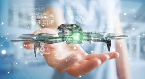 Small drone hovering over hand