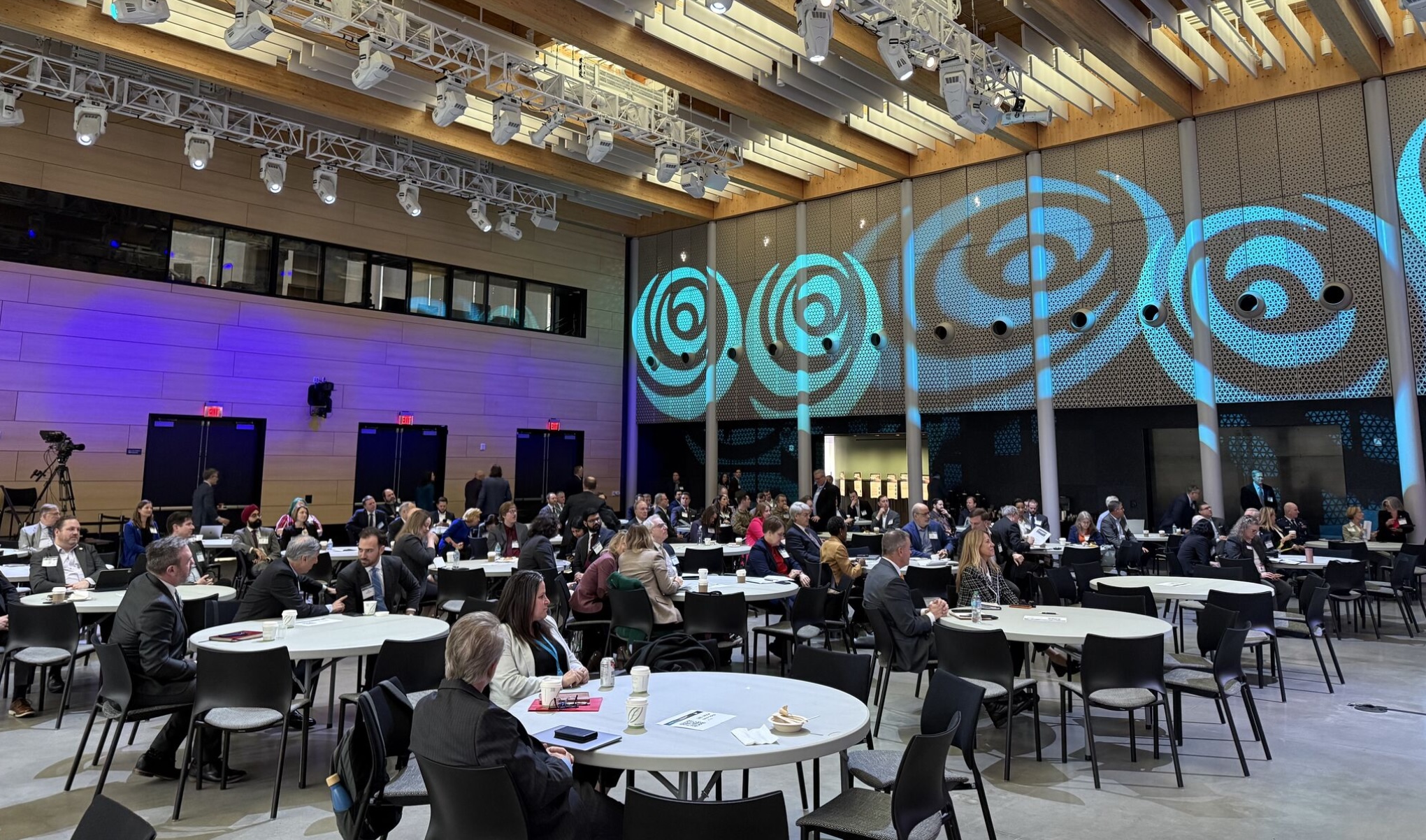 Attendees at a conference sit at tables at Amazon's HQ2
